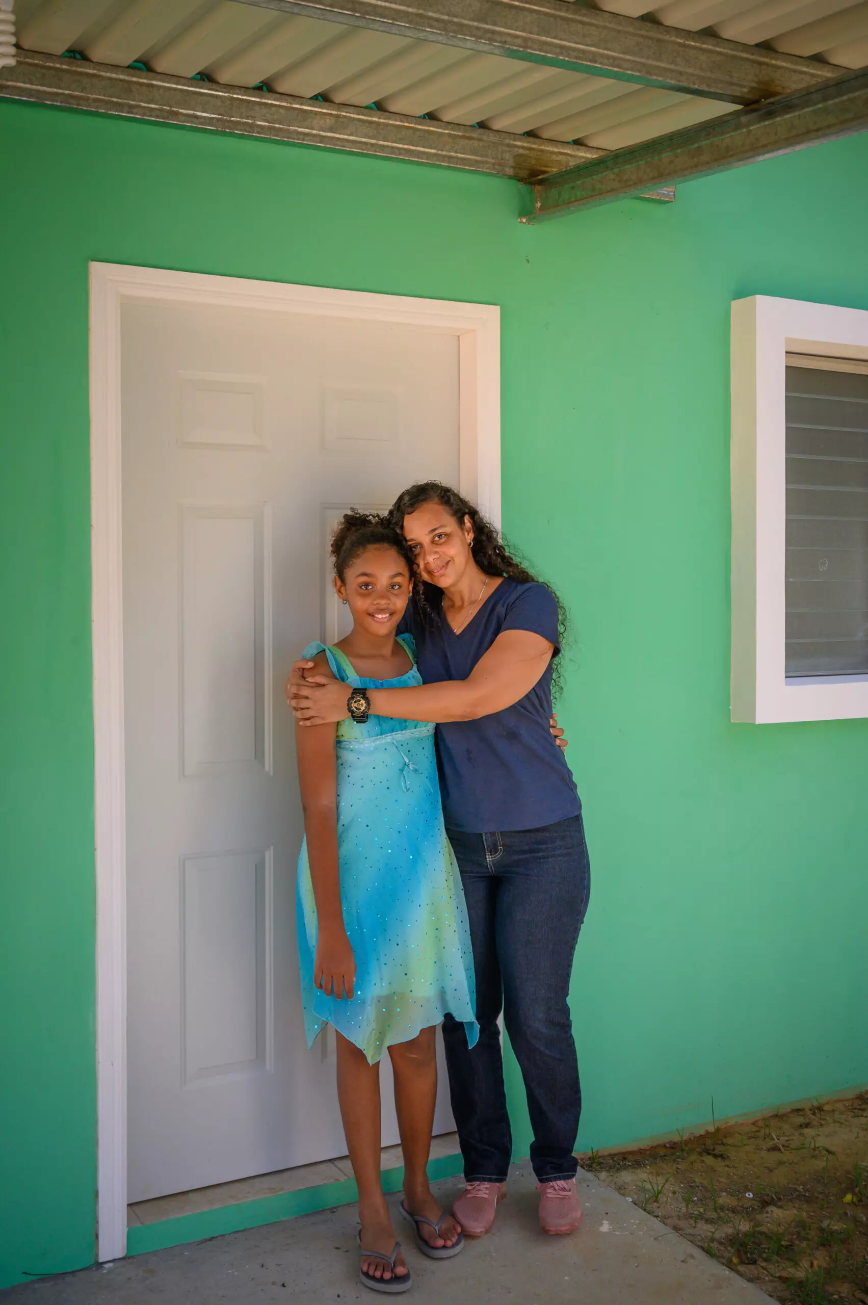 Roatan homeowner and her daughter standing in front of their house